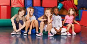 Gruppe Kinder sitzt in Turnhalle